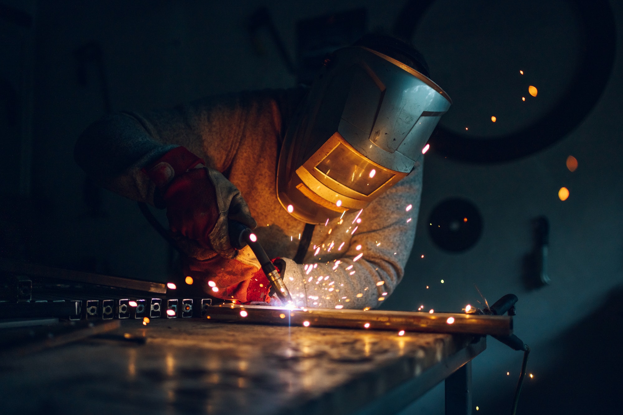 Worker welding metal with a welding machine in the SNM workshop