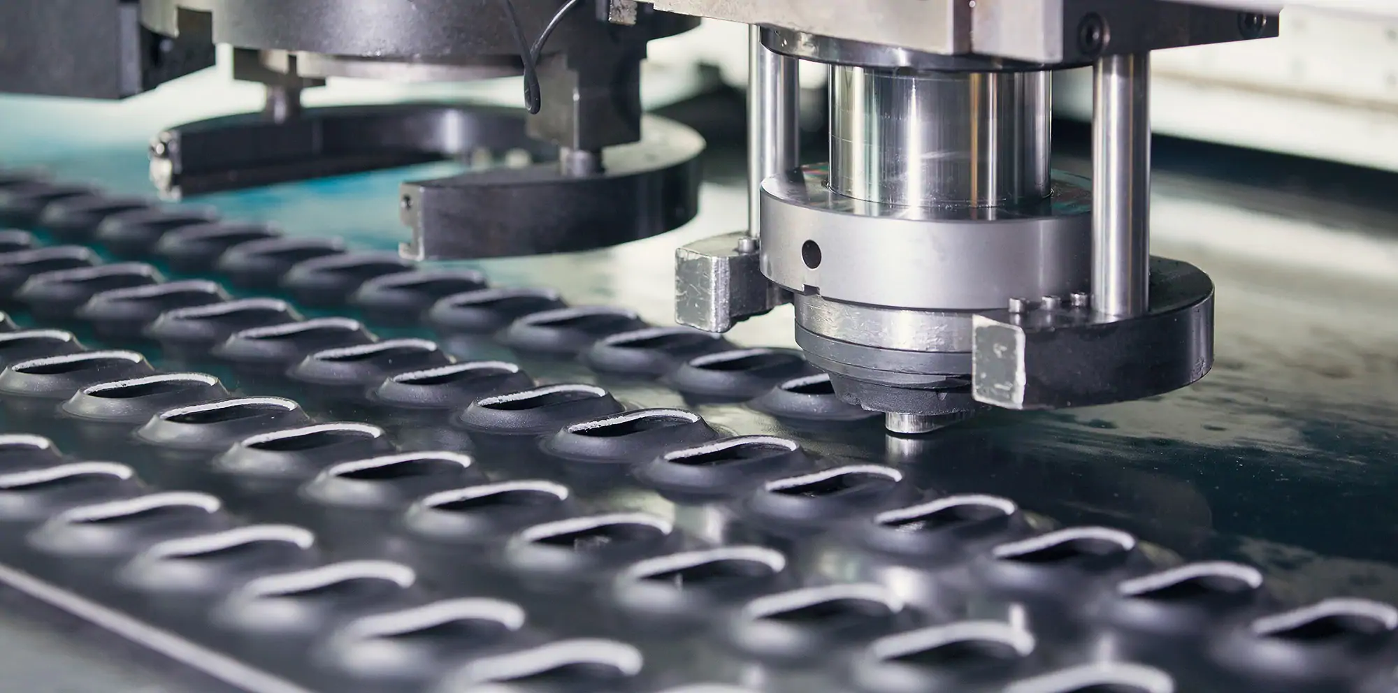 CNC punching machine forming a sheet metal panel